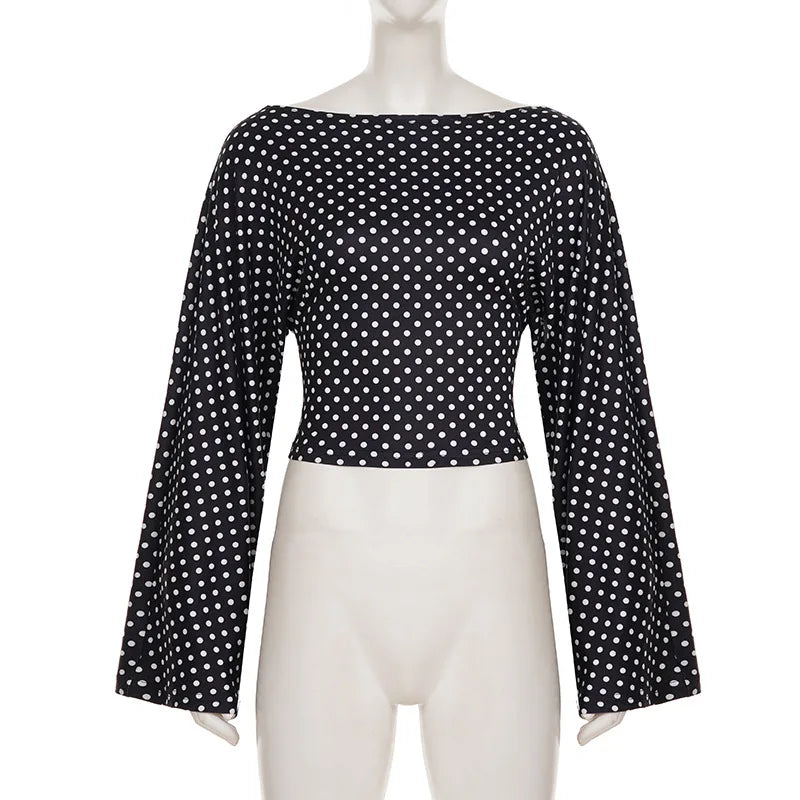 Black polka dot blouse on a mannequin against a white background