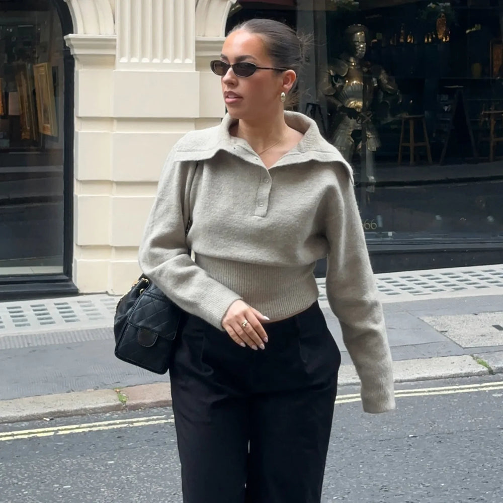 Knitted polo sweater styled with a crossbody bag and dark trousers on a city afternoon