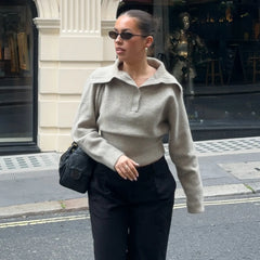 Knitted polo sweater styled with a crossbody bag and dark trousers on a city afternoon
