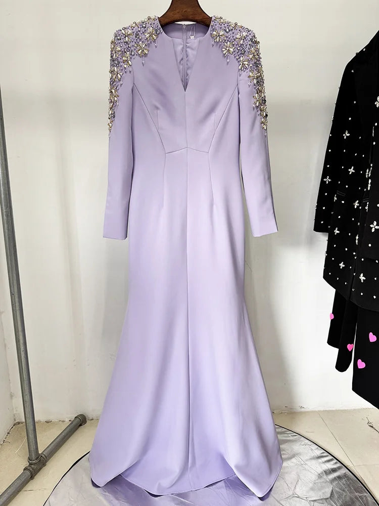 Lavender evening gown with embellishments on a hanger against a neutral background