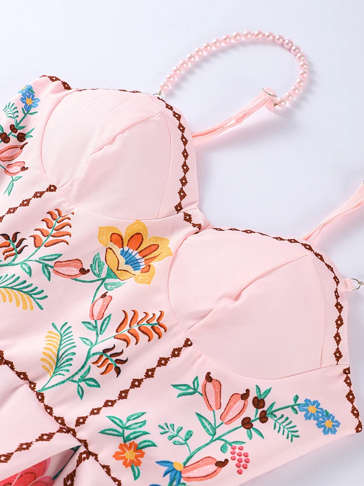 Pink bra with floral embroidery on a light blue background