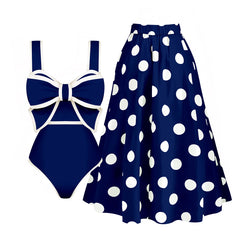 Navy blue polka dot tankini top with white bow detail and a matching A-line skirt, laid out flat.