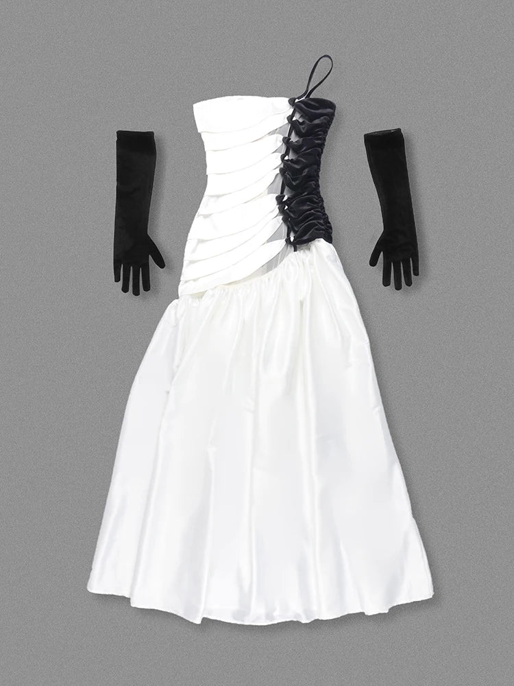 White strapless dress with black accents and gloves on a gray background