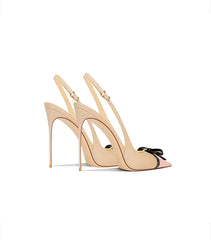 Beige high-heeled shoes with a bow on a white background