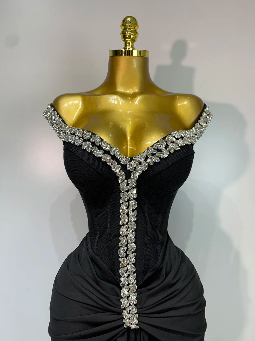 Close-up of the diamond embellishments on the neckline of a draped bandage dress