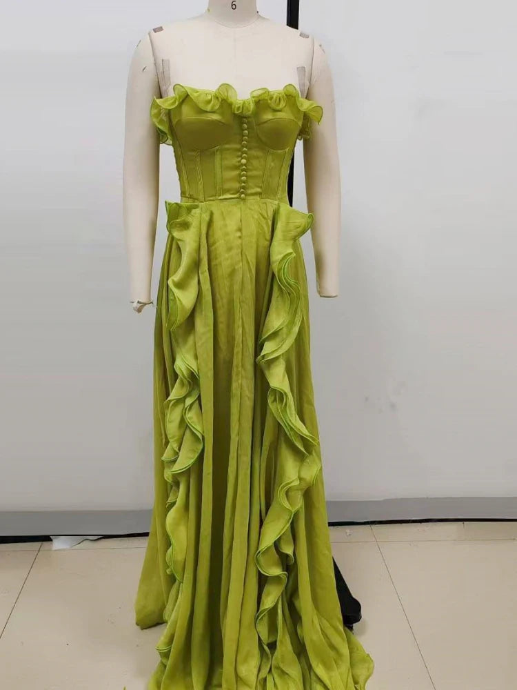 Mannequin wearing a lime green evening gown with ruffled details against a plain background