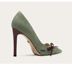 Green high-heeled shoe with a bow on a light gray background