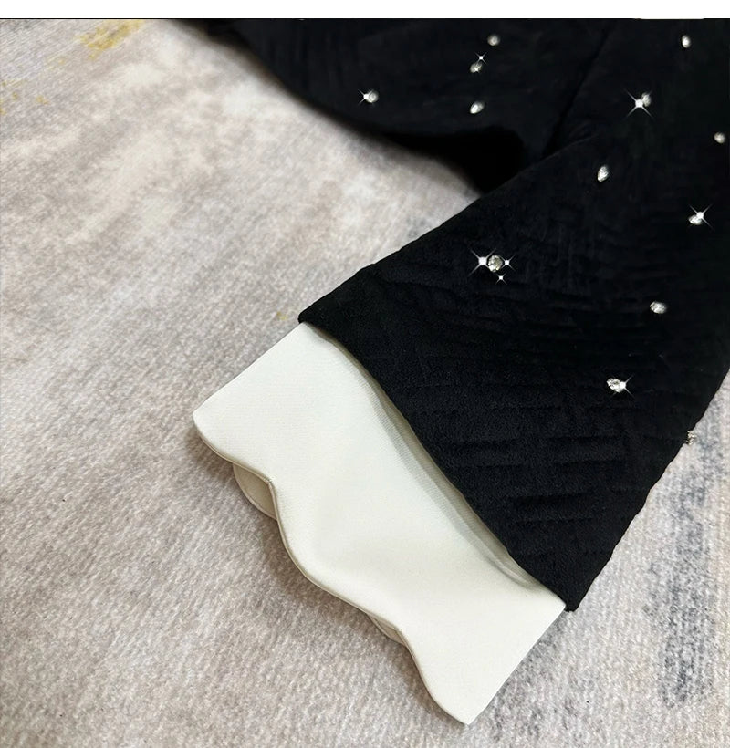 Black leggings with white rhinestone embellishments on a textured surface