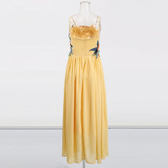 Yellow dress with floral straps on a mannequin against a white background