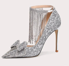 Silver high-heeled shoe with decorative elements on a white background