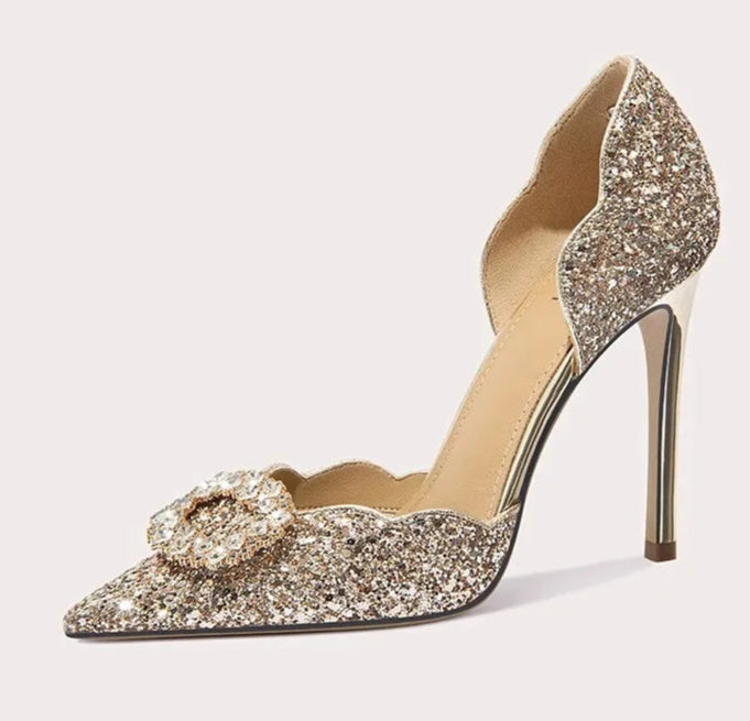Sparkly high-heeled shoe with a decorative bow on a light gray background