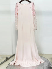 Pink evening gown with floral embellishments on a hanger against a white background