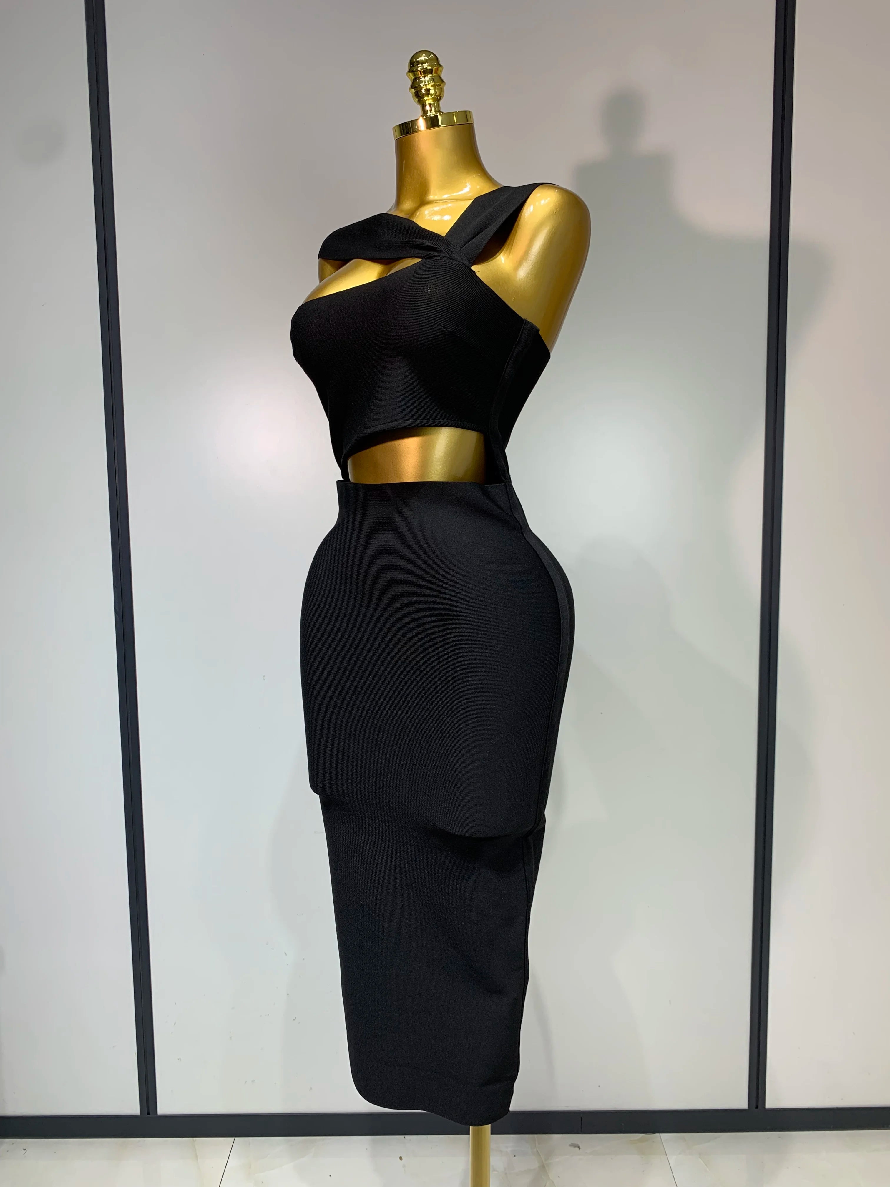 Black outfit on a gold mannequin against a white background