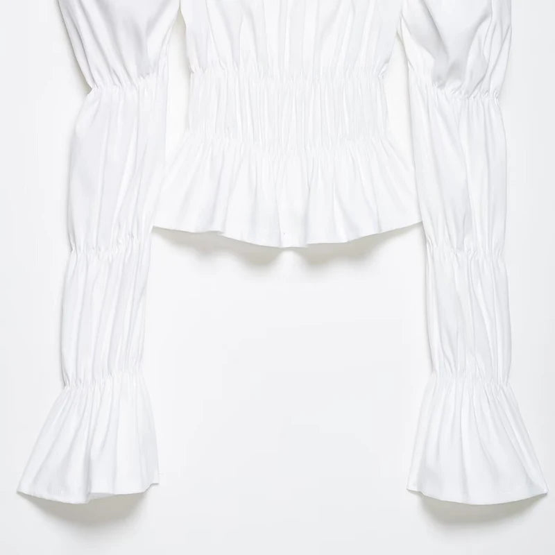 Detail of white smocked square neck puff sleeve top