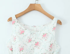 Floral-patterned top on a wooden hanger against a white background