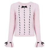 Pink cable knit sweater with black velvet bow embellishments