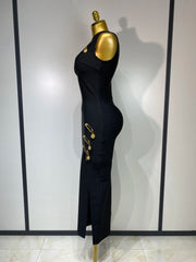 Black dress with gold buttons on a mannequin against a white wall.