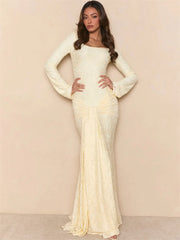 Woman wearing a long, elegant white dress against a beige background