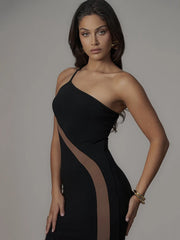 Woman wearing a black one-shoulder dress with sheer panels against a gray background