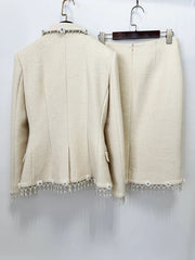 Cream woolen blazer and midi skirt set hanging on hangers