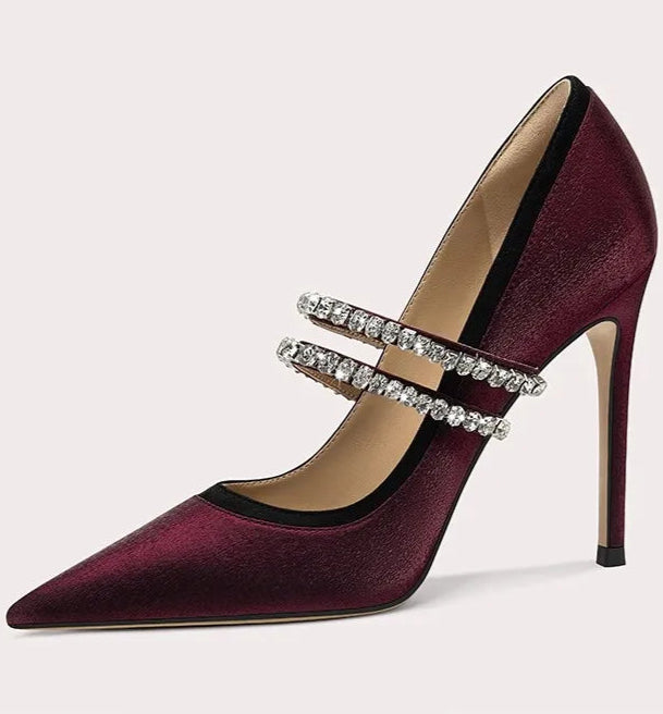 Maroon high-heeled shoe with silver strap on a light gray background