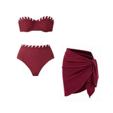 Maroon bikini top and high-waisted bottoms with white contrast trim, and a matching maroon wrap skirt.