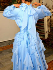 Light blue dress with ruffled layers and a bow detail on the back, worn by a person.