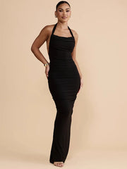 Woman wearing a black halter neck dress on a beige background