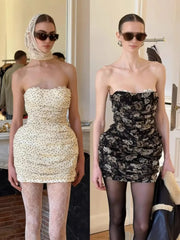 Two women wearing strapless dresses with different patterns in an indoor setting.