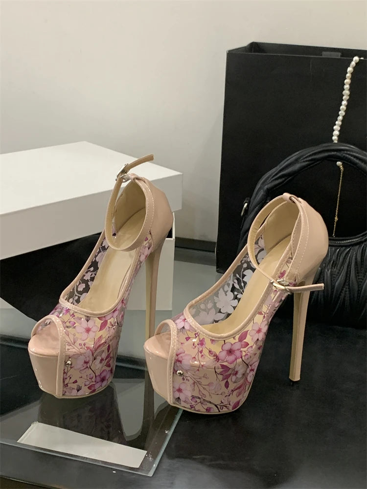 Pair of high-heeled shoes with floral pattern on a reflective surface.