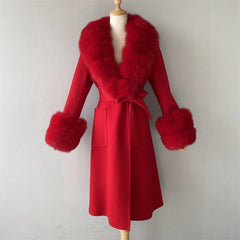 Red coat with fur trim on a mannequin against a plain background