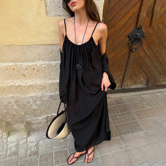 Close-up of a solid black camisole maxi dress with a draped neckline