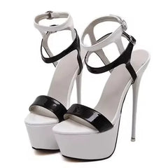 White high-heeled platform shoes with black patent leather straps on a white background