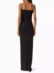 Black evening gown with thin straps and a slit on a white background