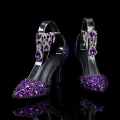Purple high-heeled shoes with gemstones on a black background