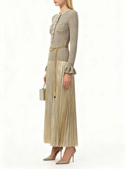 Woman wearing a beige pleated dress with a matching jacket on a white background