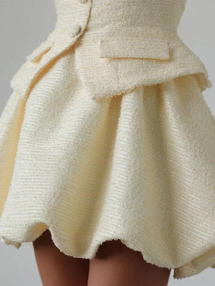 Close-up of a textured beige skirt with a plain background