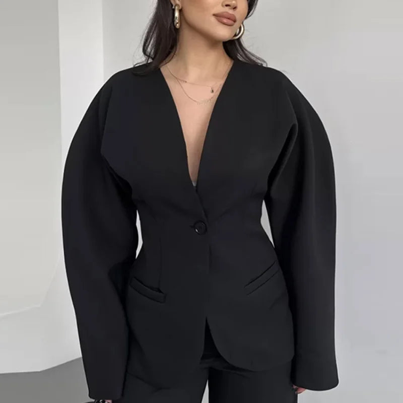 Black blazer worn by a person on a plain background