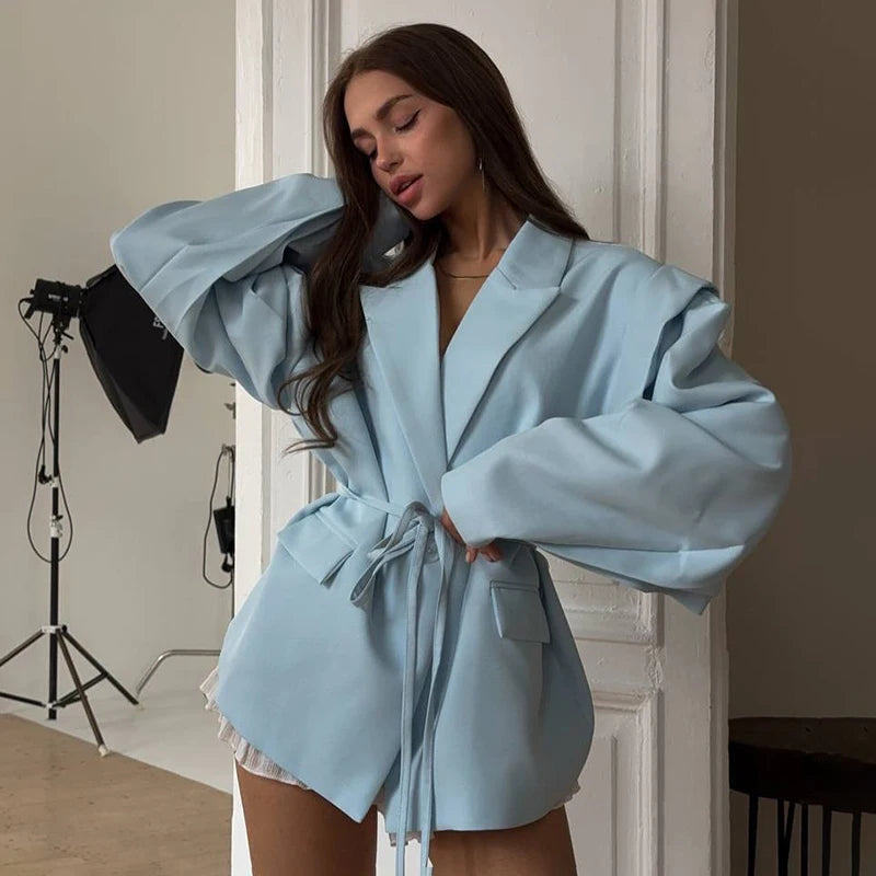 Woman wearing a light blue robe in a studio setting