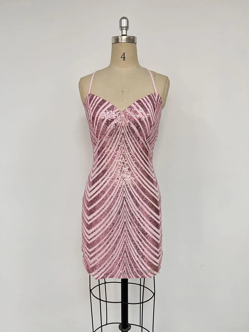 Pink sequin dress on a mannequin against a white background