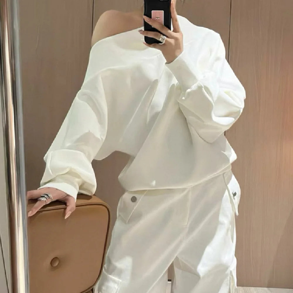 Person wearing a white outfit taking a mirror selfie.