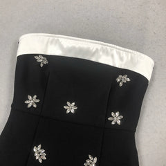 Black strapless top with silver floral embellishments on a gray background