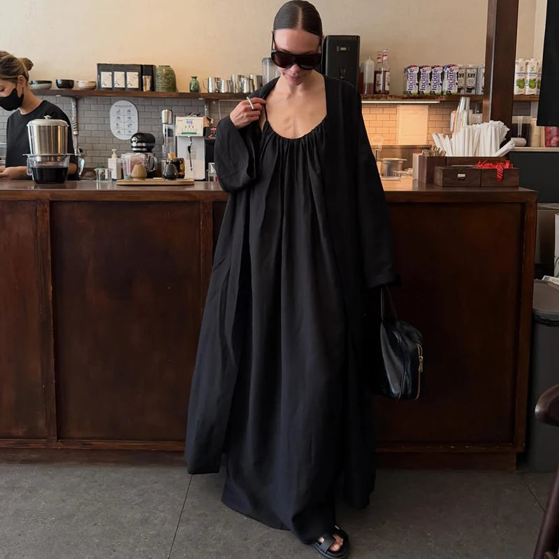 Woman in a solid black maxi dress with a loose fit