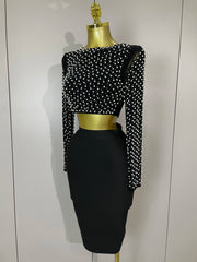 Black pearl embelished top and skirt set with long sleeves on a mannequin against a white background.