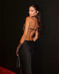 Woman in a black outfit with a deep neckline against a dark background