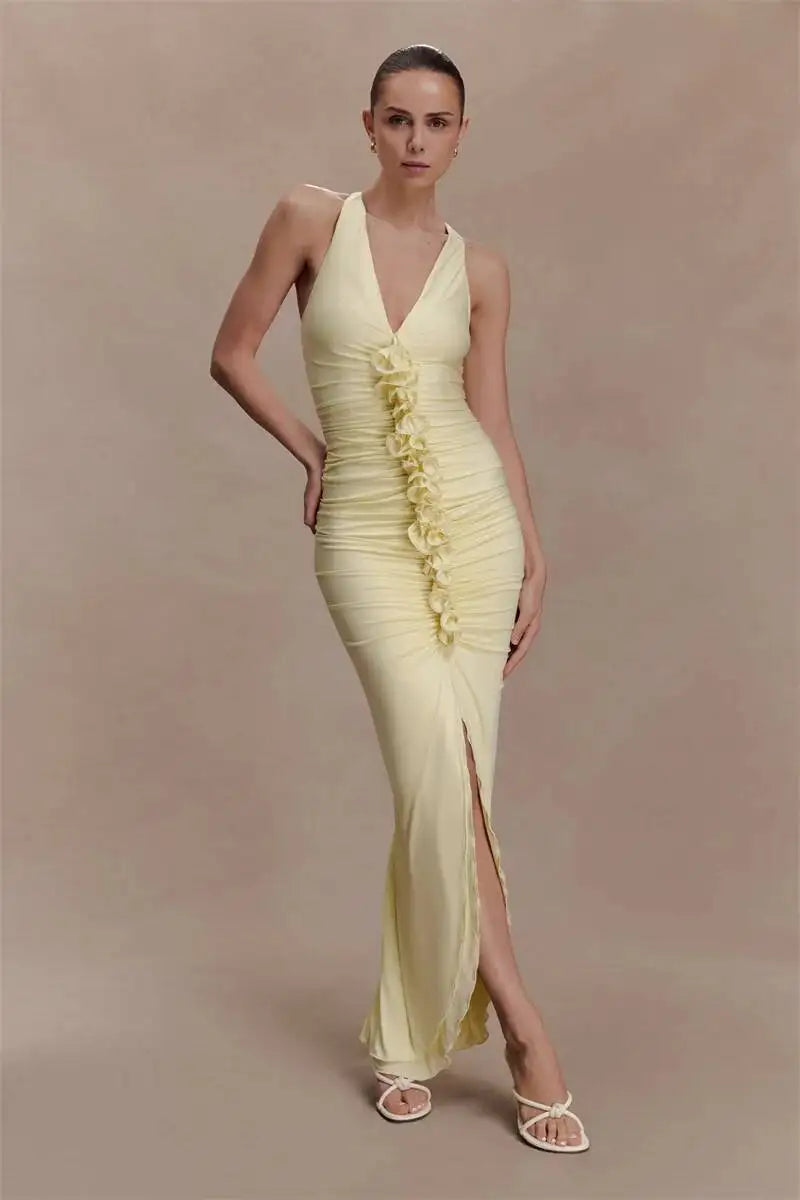 Woman wearing a yellow evening gown with floral details on a beige background