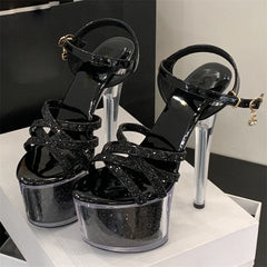 Black high-heeled shoes with glittery straps on a white surface
