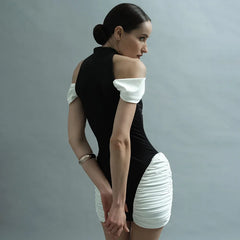 Woman wearing a black and white dress against a gray background