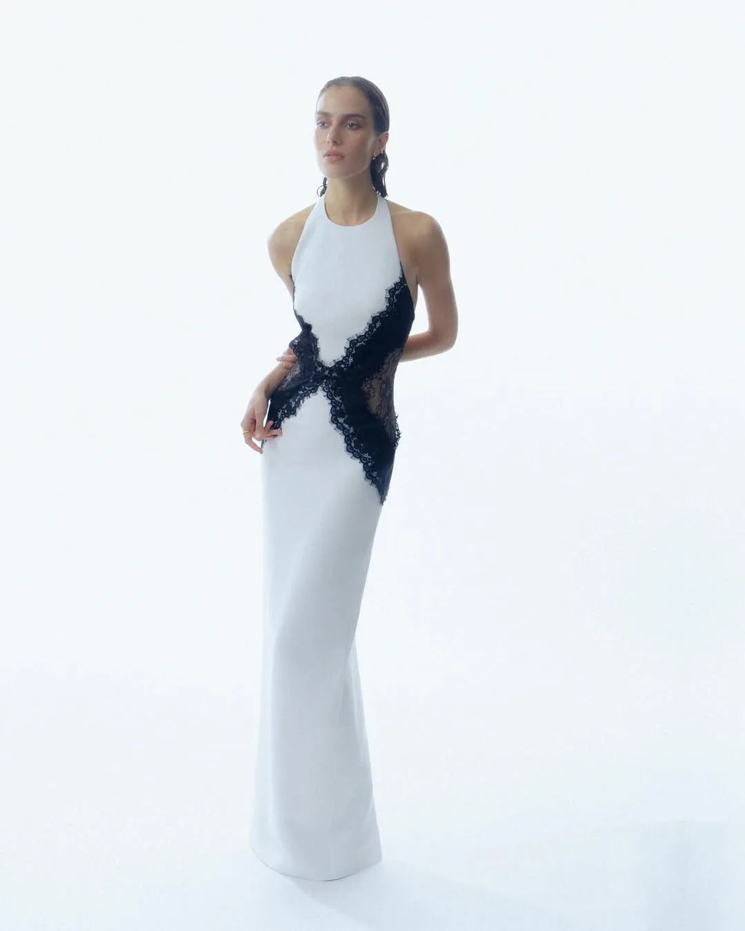 Woman wearing a white evening gown with black lace details