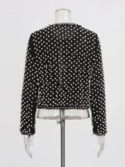 Black beaded top on a mannequin against a white background